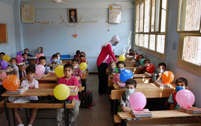 Pupils attend a lesson on their first day back at school in Homs, Syria.  AP