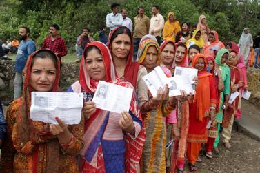 Indian women hold their voting papers as they queue to cast their ballots at a polling station in Kashmir two years ago. Indians who live overseas can only vote at home if they travel back to their constituencies to cast their ballot. EPA