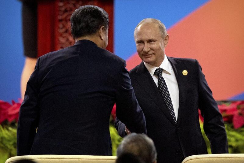Chinese president Xi Jinping, left, shakes hands with Russian president Vladimir Putin. Mark Schiefelbein / AP Photo