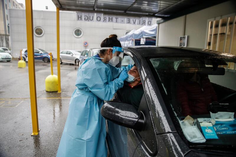 A medical worker takes swabs at a drive-through Covid-19 testing centre at the San Paolo hospital, in Milan, Italy. AP Photo