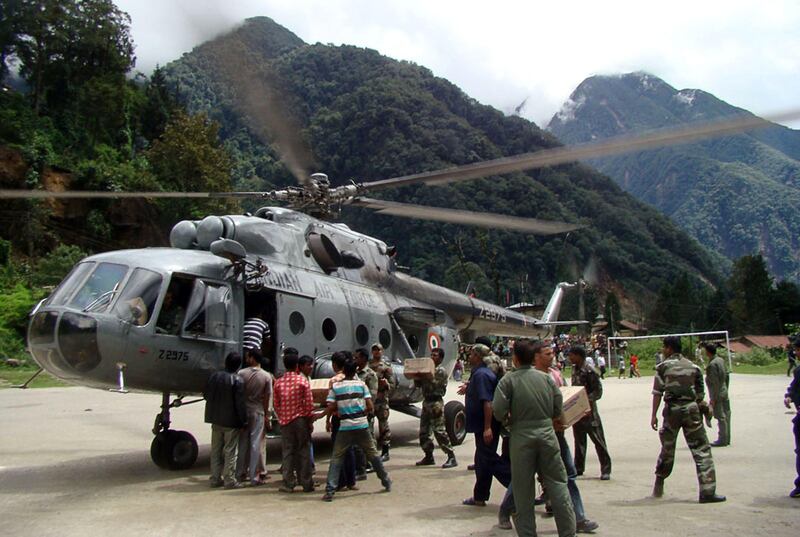 Indian Air Force personnel load relief supplies onto a helicopter during relief operations in the earthquake affected areas of the state of Sikkim on September 20, 2011. Before the grim search for more victims can even begin, the main challenge after the September 18 6.9-magnitude quake is to reach the isolated, mountainous impact zone on the border between India's northeastern Sikkim state and Nepal. AFP PHOTO /STR
 *** Local Caption ***  872801-01-08.jpg