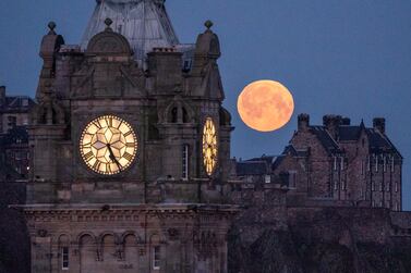 The pink moon sets behind the Balmoral Clock and Edinburgh Castle on Wednesday. PA