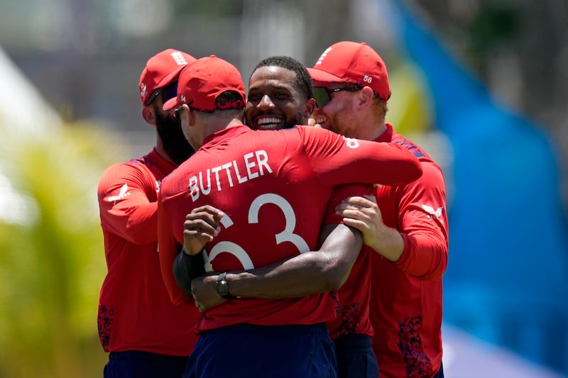 England's Chris Jordan is hugged by captain Jos Buttler after completing his hat-trick as USA were bowled out for 115 after 18.5 overs. AP