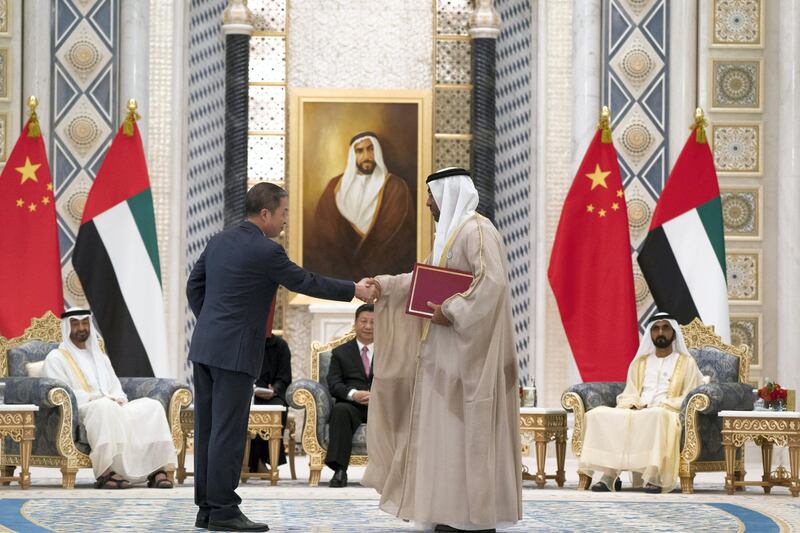 ABU DHABI, UNITED ARAB EMIRATES - July 20, 2018:  HE Ahmed Ali Al Sayegh, Chairman of Abu Dhabi Global Market (R), exchanges an MOU with a member of the Chinese delegation, at the Presidential Palace. Witnessed by HH Sheikh Mohamed bin Rashid Al Maktoum, Vice-President, Prime Minister of the UAE, Ruler of Dubai and Minister of Defence (back R), HE Xi Jinping, President of China (back C) and HH Sheikh Mohamed bin Zayed Al Nahyan, Crown Prince of Abu Dhabi and Deputy Supreme Commander of the UAE Armed Forces (back L).

( Mohamed Al Hammadi / Crown Prince Court - Abu Dhabi )
---