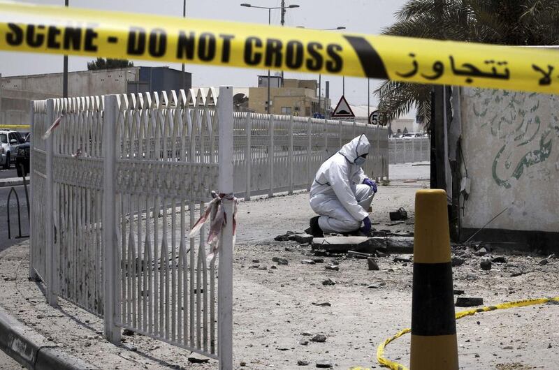 A Bahraini forensic police officer inspects the site of a bomb blast in the village of Sitra, south of Manama. Mohammed Al Shaikh/AFP