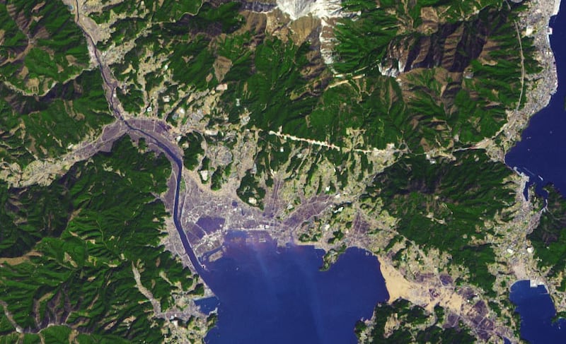 22.	A satellite image taken after a 9.1 magnitude earthquake struck the Tohoku region in Japan, with tsunami waves destroying most of the coastal area. About five to 10 metre waves flooded into the town. The photo shows flooding, a destroyed seawall and debris. Photo: Nasa Earth Observatory