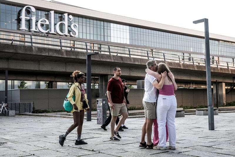 People comfort each other in front of Field's shopping centre after the shooting. Reuters