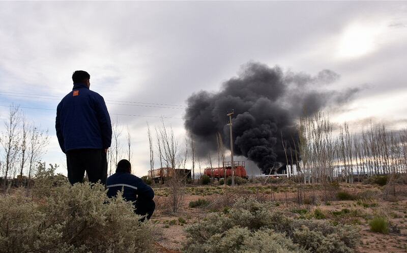 Workers from the New American Oil refinery watch smoke rising after an explosion killed several colleagues. Reuters