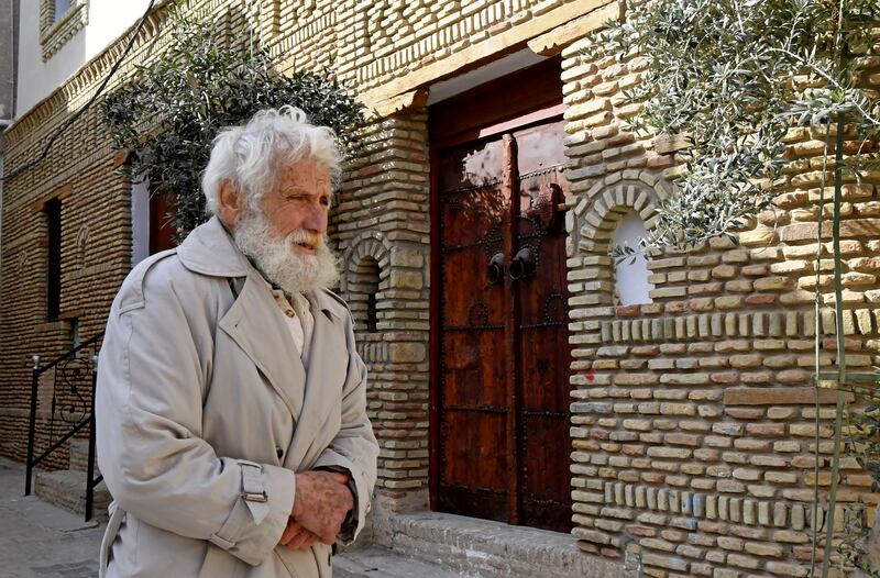 Tunisian teacher Dhouib walks past a traditional house.