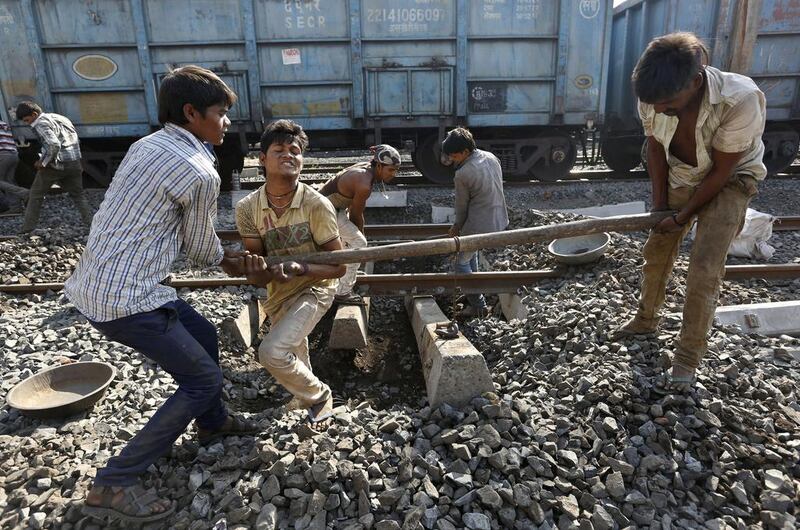 Labourers repair a railway track at a railway station in Ahmadabad. Once a pride of the Indian government, the railway sector is now hobbled by ageing infrastructure. Ajit Solanki / AP Photo