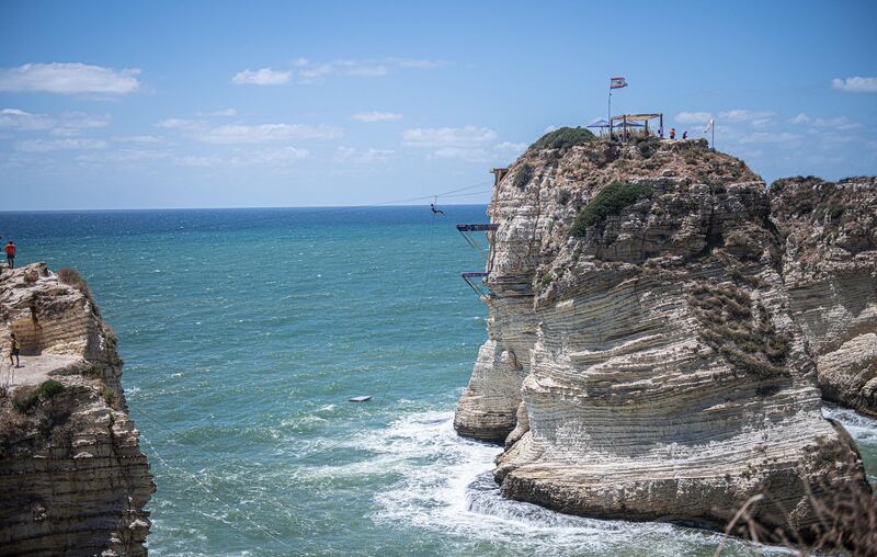 Miguel Garcia of Colombia is transported across to the dive location on a zip-line in Raouche during the first competition day of the fifth stop of the Red Bull Cliff Diving World Series. Getty Images