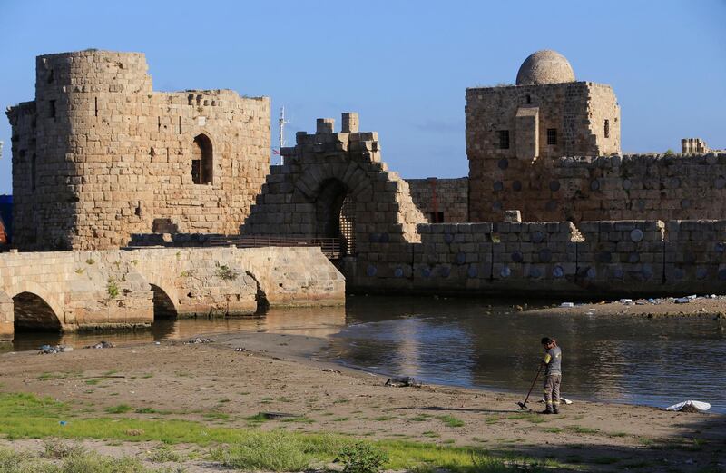 A worker cleans a beach outside the closed sea castle of the port city of Sidon. Reuters