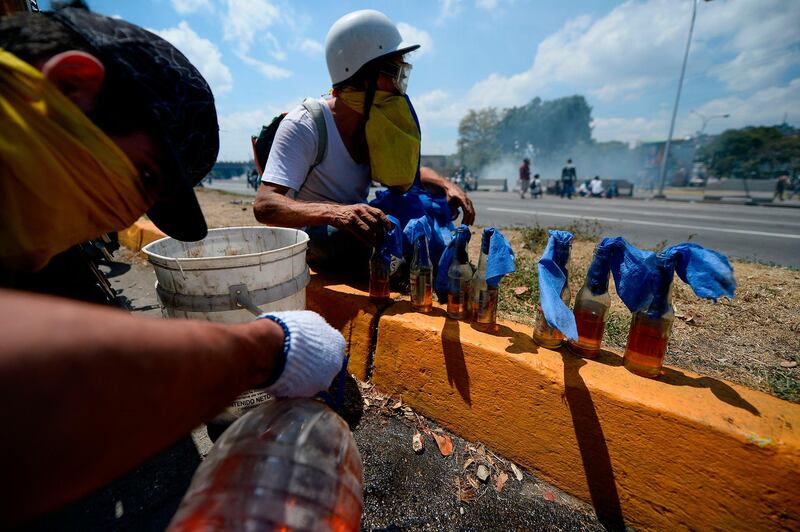 Opposition demonstrators prepare Molotov cocktails during clashes with soldiers loyal to Mr. Maduro. AFP