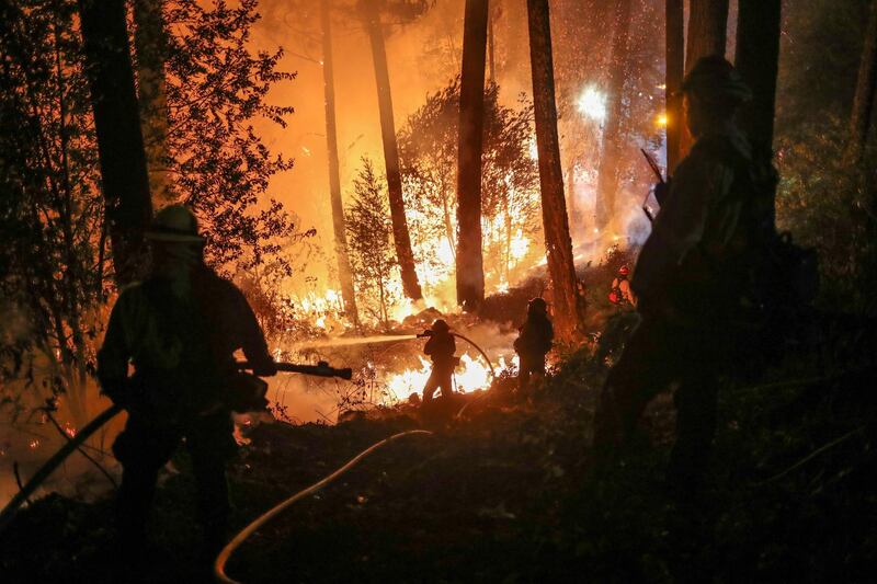 Firefighters battle the Glass Fire as it encroaches towards a residence in Calistoga, California, USA. Reuters