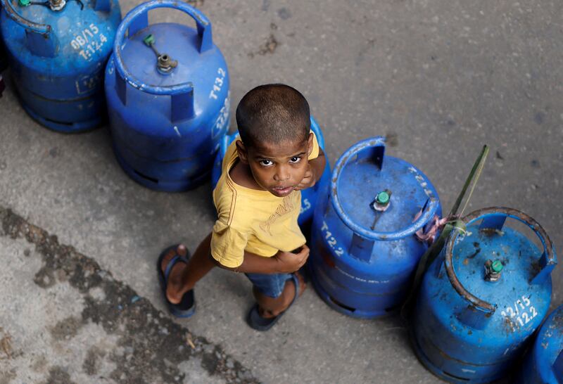A boy stands by empty cylinders as queues to buy domestic gas at a distribution centre, amid the country's economic crisis, in Colombo, Sri Lanka. Reuters