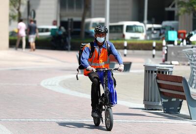 Dubai, United Arab Emirates - N/A. News. Coronavirus/Covid-19. A man makes his deliveries on a moped in the marina. Friday, September 11th, 2020. Dubai. Chris Whiteoak / The National