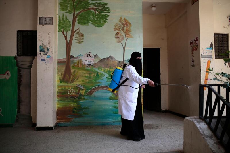 A worker disinfects a school as a preventive measure against the spread of the new coronavirus before students taking a final-term school exam at a public school in Sanaa, Yemen. AP Photo