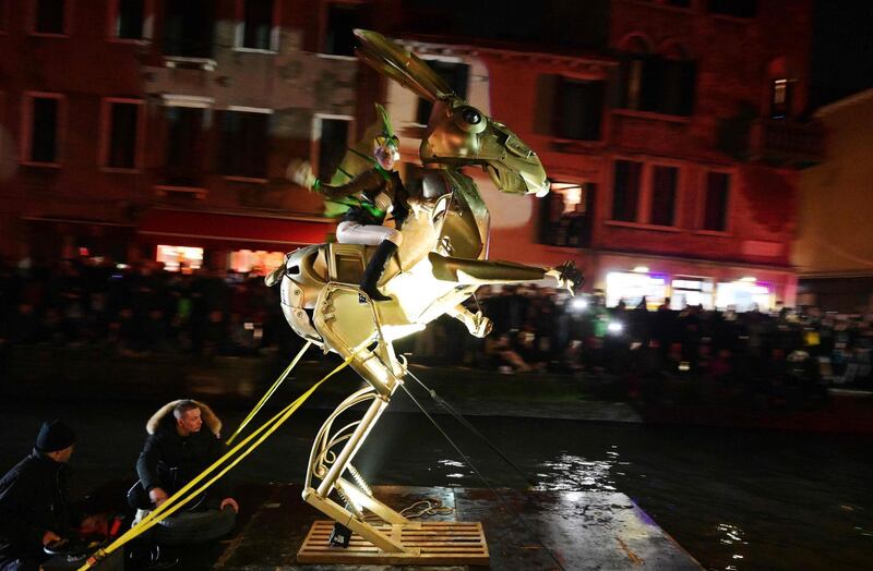 Artists perform during the 'Tutta colpa della Luna' or 'Blame the Moon' festivities down the Rio di Cannaregio, one of Venice's famed canals on February 16, 2019.  Venice began its annual Carnival festivities with a floating, night-time parade starting more than two weeks of celebrations to mark 50 years since man first walked on the moon. / AFP / Vincenzo PINTO
