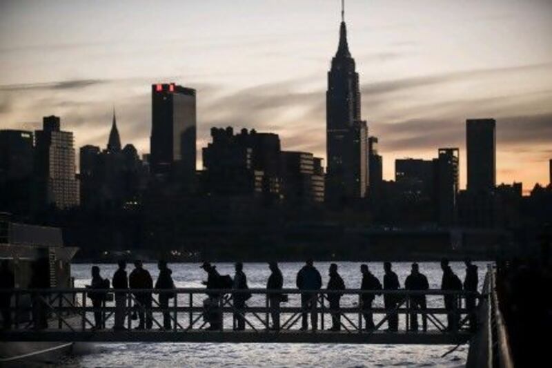 People board a NY Waterways ferry with the Manhattan skyline in the background. The ‘Frankenstorm’ Sandy left parts of the state and the surrounding area without power.