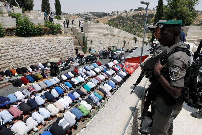epa06098425 Israeli Border Police stand guard as Palestinian worshipers pray next to the Lions gate of the old city of Jerusalem, as they refuse to pass through a new security measures imposed at the entrance to the Al-Aqsa compound, in Jerusalem, Israel, 20 July 2017. The Islamic authorities of the al-Aqsa Mosque compound, including the mufti of Jerusalem, called on Palestinian Muslims not to go through the electronic gates installed by the Israeli police and rejected all procedures that change the historic situation of the mosque. Israel authorities installed metal detectors at the entrance to the al-Aqsa compound after a shooting attack carried out by Israeli Arabs against Israeli police on 14 July at the al-Aqsa compound, which resulted in the deaths of two Israeli policemen and the three attackers.  EPA/ABIR SULTAN