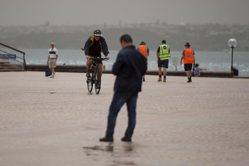 A cyclist pedals as a dust storm approaches Sydney. EPA
