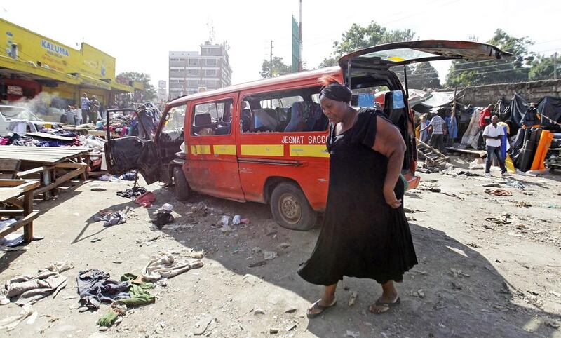 A woman walks near a damaged vehicle at the scene of a twin explosion at the Gikomba open-air market for second-hand clothes in Kenya’s capital Nairobi. Thomas Mukoya / Reuters