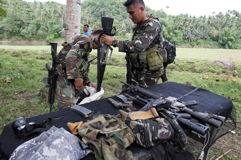 Filipino soldiers collect confiscated firearms from killed Abu Sayyaf members in the Philippine town of Ibanga on April 12, 2017.