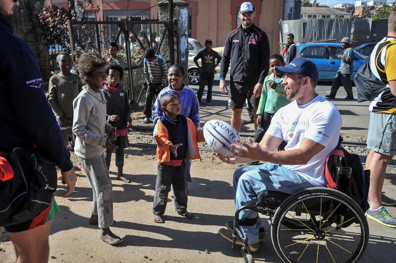 Mike Ballard passes the ball to children, who had followed the Conquistadors team from their hotel to the stadium for their training session in Antananarivo. 1 July 2016. Photo: Rafalia Henitsoa for The National