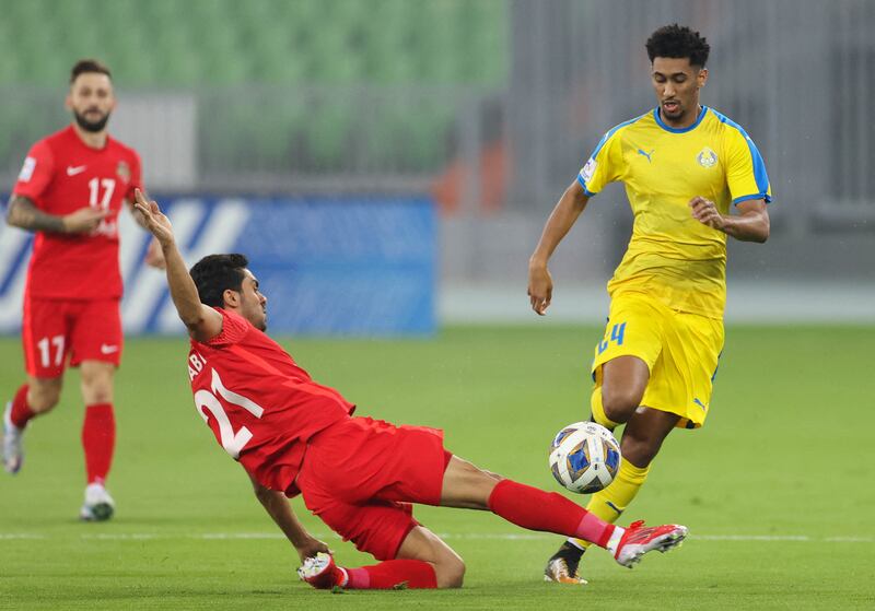 Al Gharafa defender Homam Ahmed is tackled by Shabab Al Ahli defender Mohammed Jaber. AFP