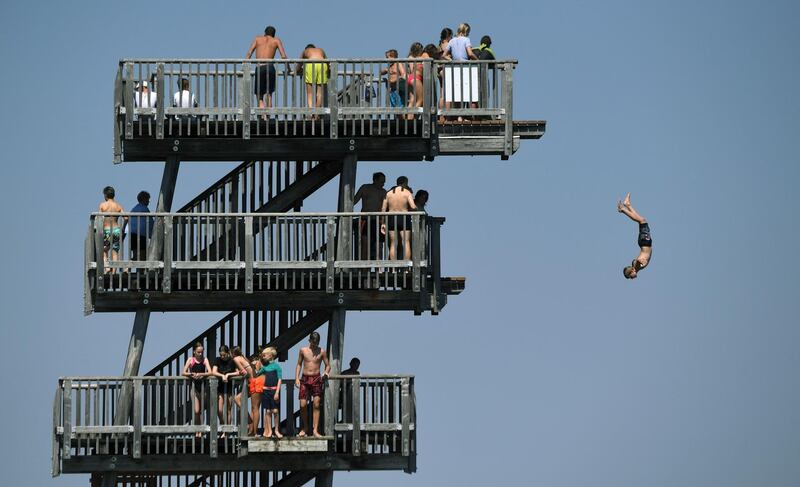 People line up to jump off a diving tower on the shore of the lake Ammersee near the small Bavarian village of Utting, southern Germany.  AFP