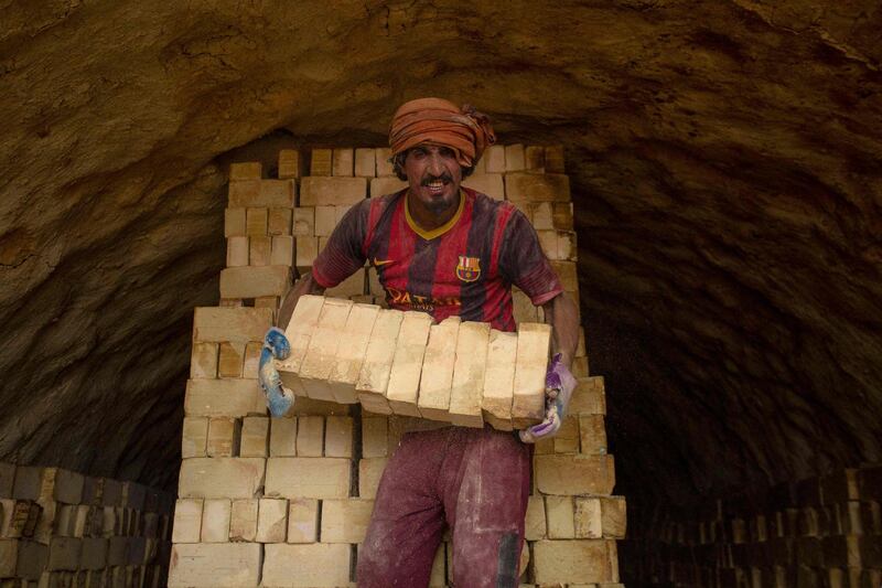 A worker stacks bricks at a small factory in the al-Tib area of the southern Iraqi Maysan governorate renowned for this traditional manufacturing.  AFP