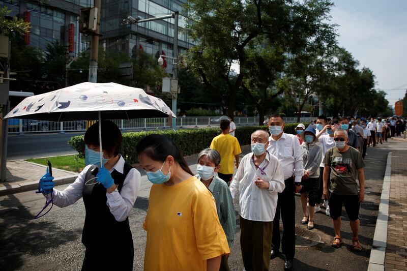 People line up in the heat for a test. Reuters