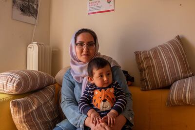 An Afghan asylum seeker holds her child while receiving advice and support from Amurtel in central Athens, Greece. Fahrinisa Campana for The National