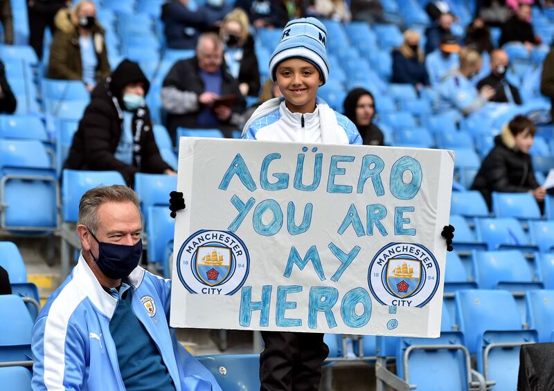 A Manchester City fan with a sign for Sergio Aguero in May 2021. PA