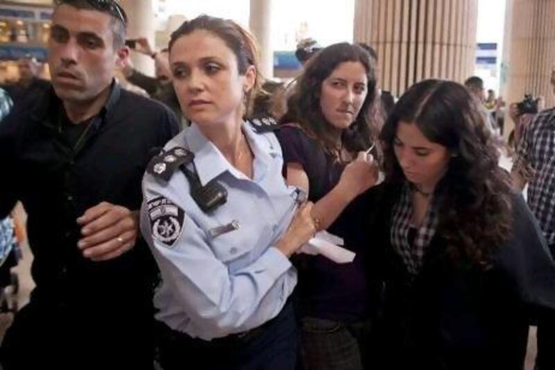 An Israeli pro-Palestinian activist is detained by police at Ben Gurion airport in Tel Aviv yesterday as the planned 'flytilla' of about 1,200 mainly European protesters aiming to visit the occupied West Bank barely got off the ground, with dozens of them arrested.