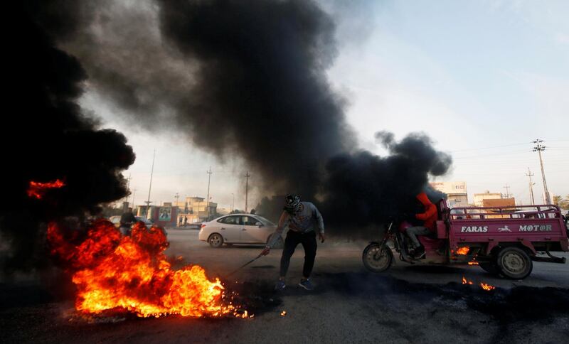 An Iraqi protester burns tires during ongoing anti-government protests in Basra. REUTERS