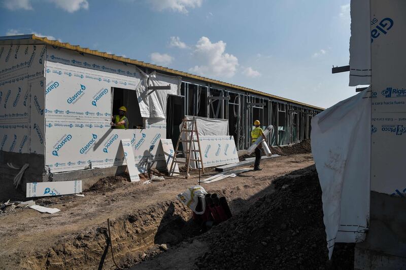 (FILES) In this file photo taken on October 22, 2019 builders work on the construction site of the refugee camp of Ritsona for the expanding of the housing facilities, some 80km north of Athens on October 22, 2019. Greece will shut down the three largest of its overcrowded migrant camps on islands facing Turkey, and replace them with new closed facilities with much larger capacity, officials said on November 20, 2019. Three camps are to be closed, on the islands of Lesbos, Chios and Samos, currently housing over 27,000 people under terrible conditions which have been repeatedly castigated by rights groups. They have a nominal capacity of just 4,500. / AFP / Louisa GOULIAMAKI
