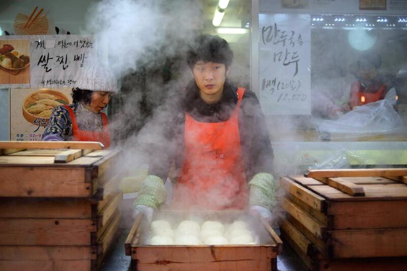 A vendor prepares Korean "mandu" dumplings at a market in Seoul on December 11, 2014. South Korea's jobless rate inched down in November from a month earlier, with new jobs being created in a number of service and manufacturing industries, government data showed on December 10. Ed Jones / AFP