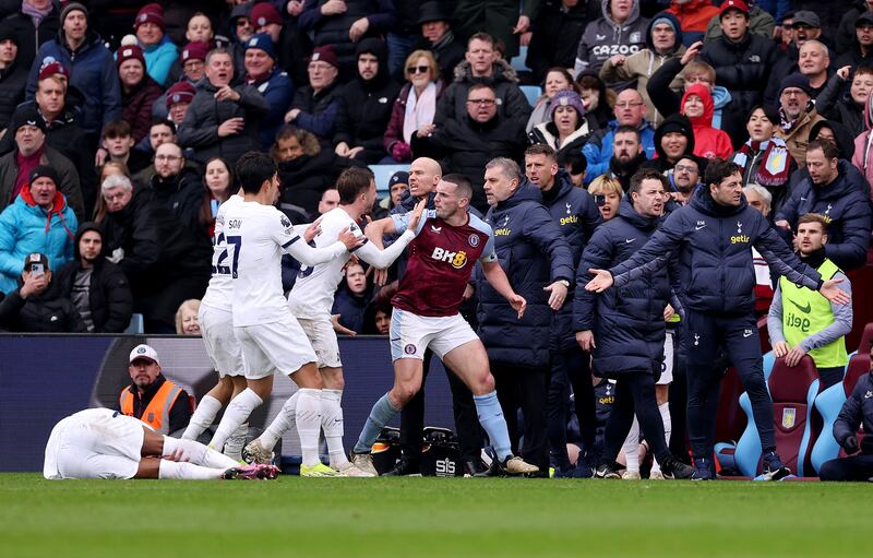 Tottenham Hotspur players confront John McGinn after his dangerous challenge on Destiny Udogie, left, which earned the Aston Villa captain a red card. Getty Images