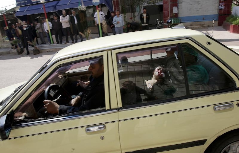 A fatally injured man lies in the back of a vehicle as he is rushed to a hospital in Deraa, the city south of Damascus where the Syrian conflict erupted in 2011. Anwar Amro / AFP