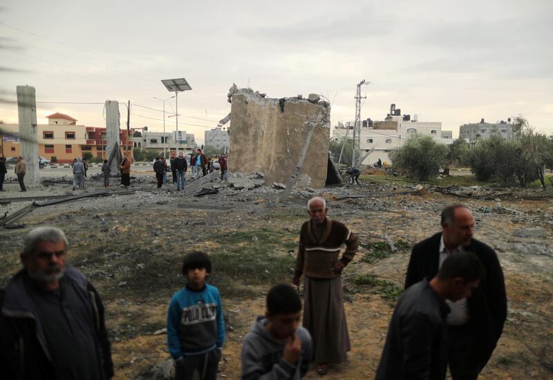 Palestinians gather around the remains of a building. Reuters