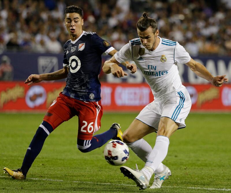 Real Madrid 's Gareth Bale, right, shoots against MLS All-Stars' Miguel Almiron during the second half of the MLS All-Star Game, Wednesday, Aug. 2, 2017, in Chicago. Real Madrid won 4-2 in a penalty shootout. (AP Photo/Nam Y. Huh)