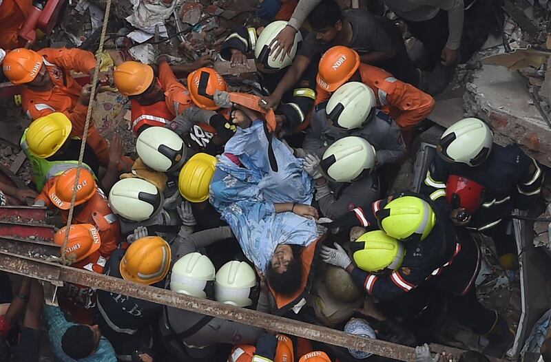 Personnel rescue a survivor. AFP