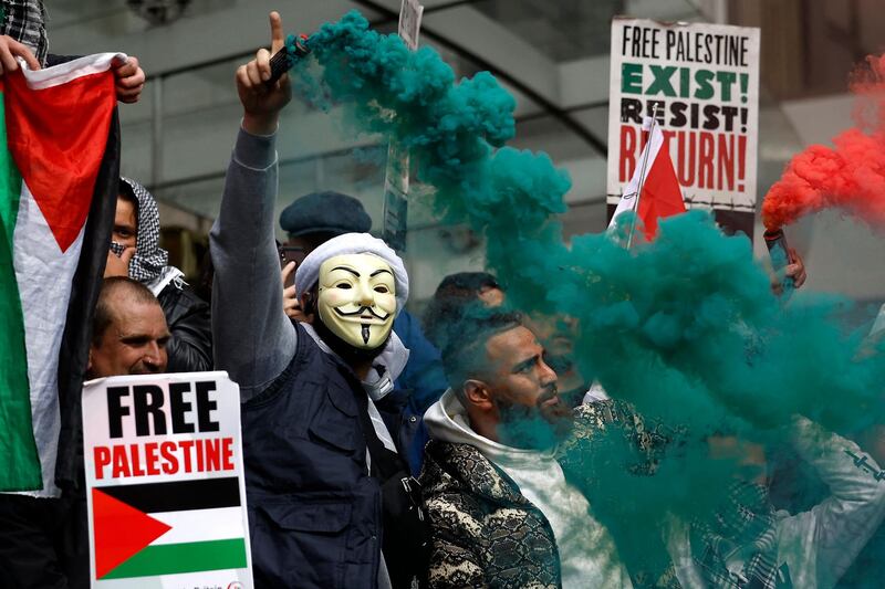 Demonstrators with flares, flags and placards during a demonstration of support for Palestinians outside the Israeli embassy in central London. AFP