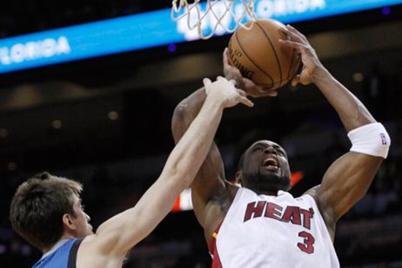 Miami Heat's Dwyane Wade shoots against Minnesota's Alexey Shved.