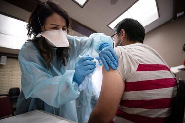 epa08746333 Miguel (R) receives a flu vaccine at a free mobile clinic in Lakewood, California, USA, 14 October 2020. Flu vaccine manufacturers have increased production in anticipation of this year's flu season. EPA/ETIENNE LAURENT