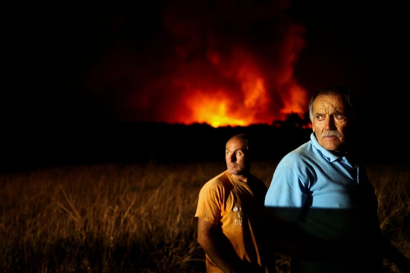 People watch as a wildfire rages in Aljezur. Reuters