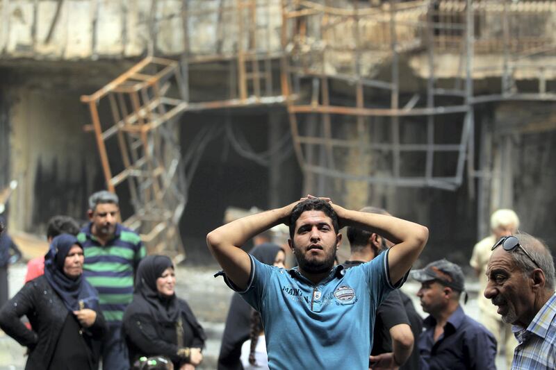 Iraqis react on July 4, 2016 at the site of a massive bombing attack which took place a day earlier in Baghdad's Karrada neighbourhood. - Iraqis mourned the more than 200 people killed by a jihadist-claimed suicide car bombing that was among the deadliest ever attacks in the country. The blast, which the Islamic State group said it carried out, hit the Karrada district early on July 3 as the area was packed with shoppers ahead of this week's holiday marking the end of the Muslim fasting month of Ramadan. (Photo by AHMAD AL-RUBAYE / AFP)