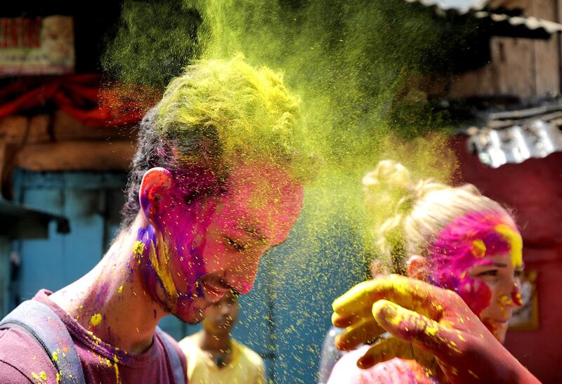 Tourists and locals apply colour dust to each other as they celebrate Holi festival in Kolkata, Eastern India. EPA