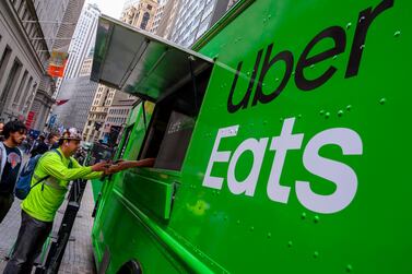 People buy food from an Uber Eats truck in front of the New York Stock Exchange. Uber has made a takeover bid for meal delivery group Grubhub. AFP